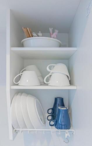 a white shelf filled with dishes and utensils at japan house Ikebukuro in Tokyo
