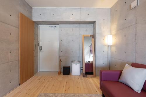 a living room with a couch and a mirror at Tamatsukuri Daifuji Kan in Osaka