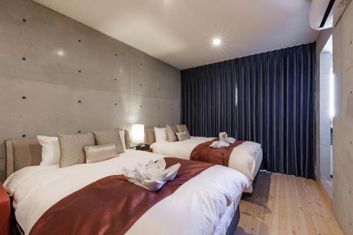 a hotel room with two beds with flowers on them at Tamatsukuri Daifuji Kan in Osaka
