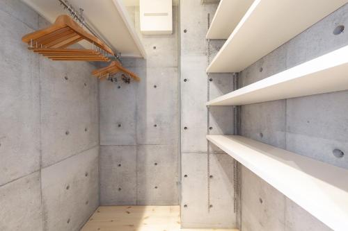 a room with concrete walls and a walk in closet at Tamatsukuri Daifuji Kan in Osaka