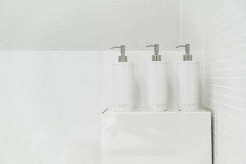 a group of four white towels on a shelf in a bathroom at Tamatsukuri Daifuji Kan in Osaka