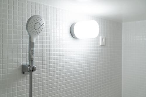 a shower with a blow dryer in a bathroom at Tamatsukuri Daifuji Kan in Osaka