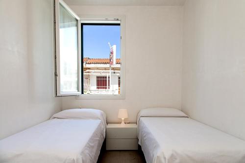 マリーナ・ディ・マンカヴェルサにあるResidence Mare Bluの窓付きの小さな部屋のベッド2台