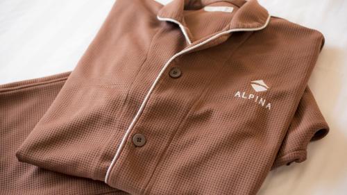 a brown shirt with a white adkin logo on it at Spa Hotel Alpina Hida Takayama in Takayama