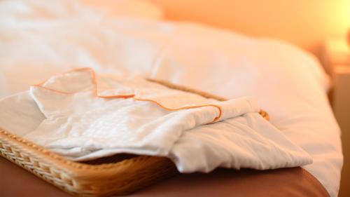 a bed with white sheets and pillows on it at Spa Hotel Alpina Hida Takayama in Takayama
