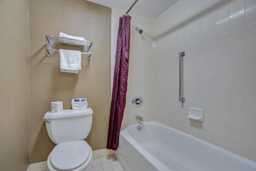 a bathroom with a toilet and a tub and a sink at Americas Best Value Inn Laredo in Laredo