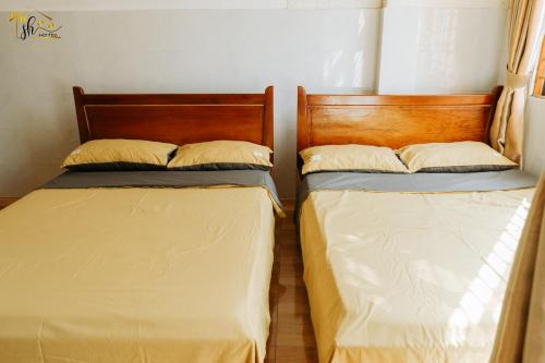 two beds sitting next to each other in a room at SH Hotel in Hue