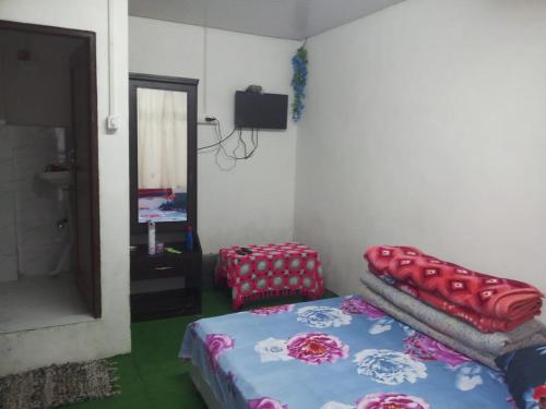um quarto com uma cama e um espelho em Vamoose Rhododendron em Darjeeling