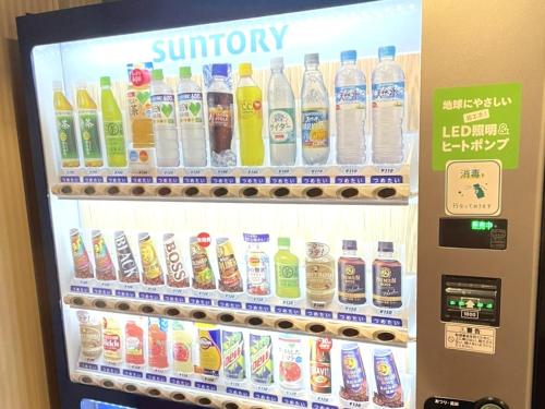 a refrigerator filled with lots of bottles of soda at Hotel The Centre Utsunomiya in Utsunomiya