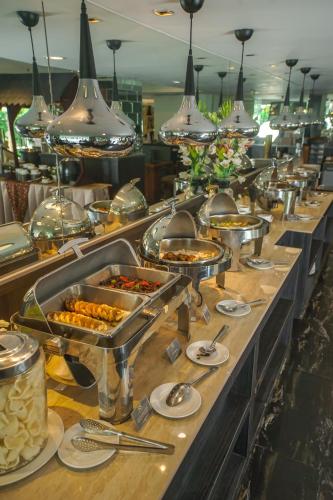a buffet line with many trays of food at Royal Regantris Cendana in Surabaya