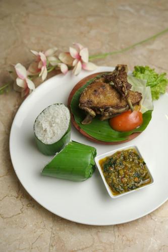 a plate of food with meat and vegetables on a table at Royal Regantris Cendana in Surabaya