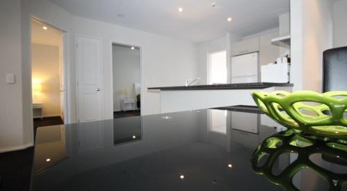 a kitchen with a green chair sitting on the floor at Carramar Motor Inn in Palmerston North