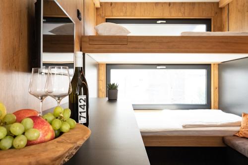 a room with a bowl of fruit and wine glasses at Uiferhäuser in Illmitz
