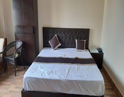 a bedroom with a large bed and a chair at Norbulinka Home Stay by StayApart in Kalimpong