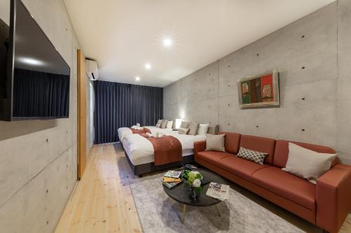 a hotel room with a bed and a couch at Tamatsukuri Daifuji Kan in Osaka
