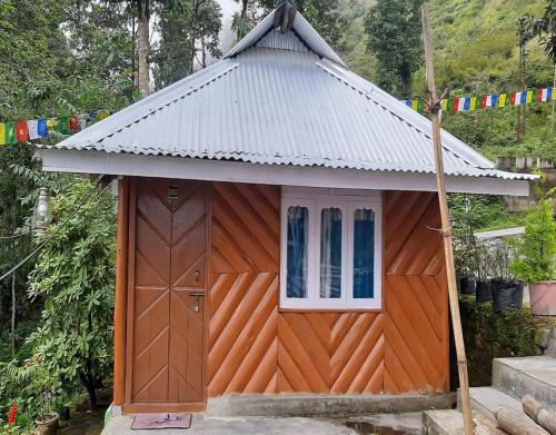 a small house with a roof on top of it at Norbulinka Home Stay by StayApart in Kalimpong