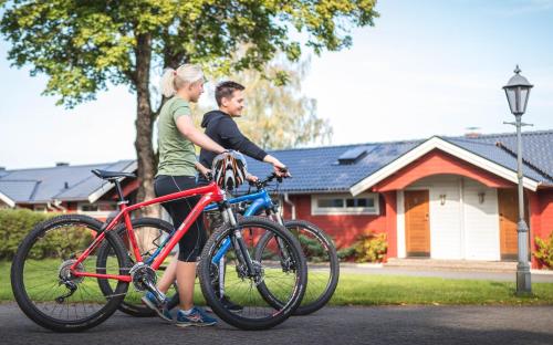 a man and a woman standing next to their bikes at Hestraviken Hotell & Spa in Hestra