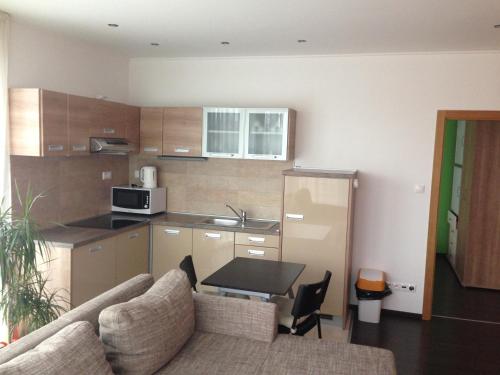a living room with a couch and a kitchen at Fine Restaurant & Apartments in Malacky