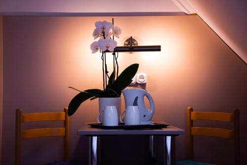 a table with a tea pot and flowers on it at Huli Panzio in Tokaj