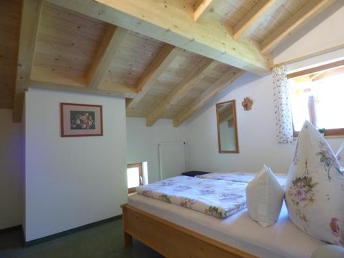 a bed in a room with a wooden ceiling at Kierngaßlehen in Schönau am Königssee