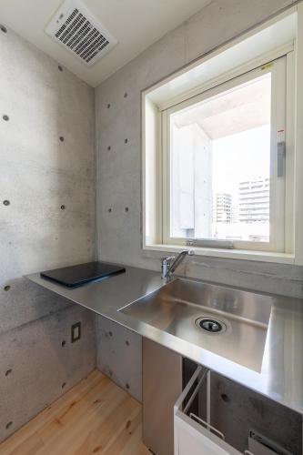 a kitchen with a sink and a window at Tamatsukuri Daifuji Kan in Osaka
