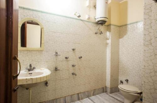 a bathroom with a sink and a toilet at Vamoose Rama Palace in Gangānagar