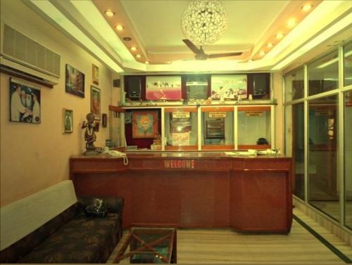 un restaurante con bar y un sofá en una habitación en Vamoose Rama Palace en Gangānagar