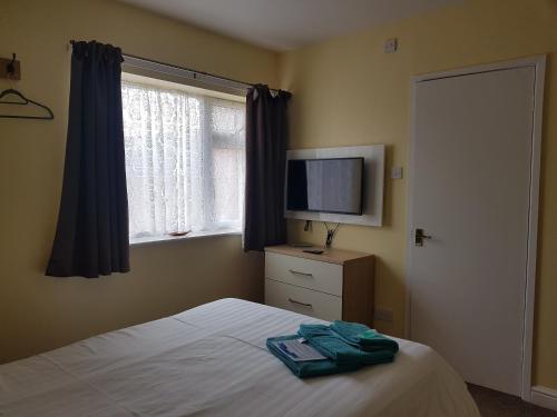 a bedroom with a bed and a tv and a window at The Beacon Hotel in Redcar
