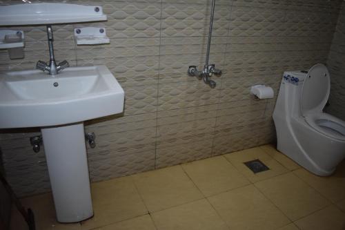 a bathroom with a sink and a toilet at Hotel Kashmir Inn in Rawalpindi