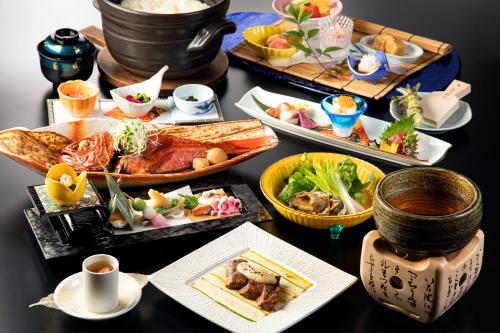 a table with many plates of food on it at Ito Kowakien in Ito