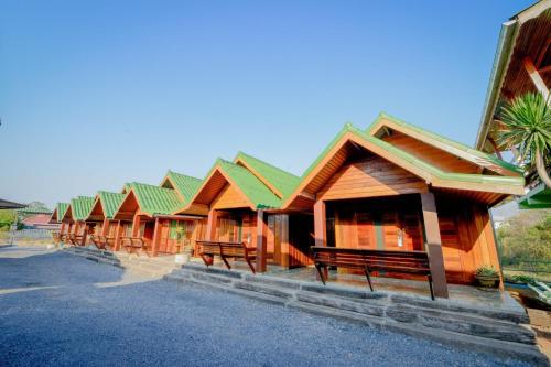 a row of wooden buildings with benches in a row at MRK Resort & Massage in Lop Buri