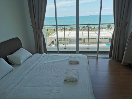 a bedroom with a bed with a view of the ocean at Bay Resort Condominium in Miri