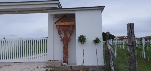 une maison blanche avec un portail et une porte en bois dans l'établissement Apartmani Bojeresku Negotin, à Negotin