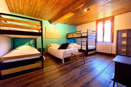 1 dormitorio con 2 literas y techo de madera en Gîte de groupe Petit Moya, Maison de Campagne, 13 personnes., en Arbas