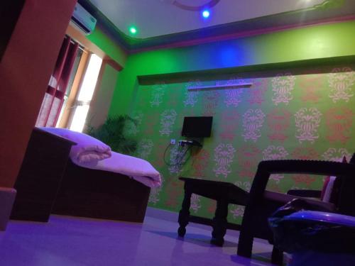 a room with a green wall and a chair and a table at Vamoose Raj Palace in Bharatpur