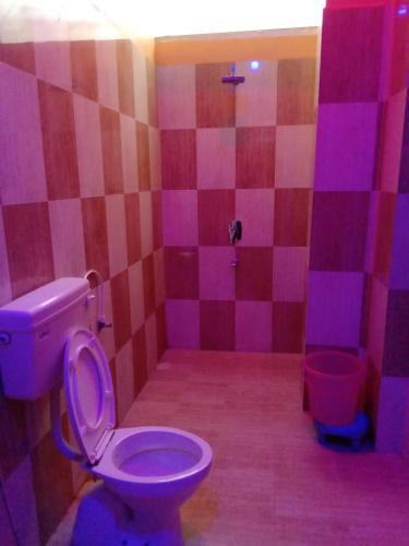 a pink bathroom with a toilet and a tub at Vamoose Raj Palace in Bharatpur