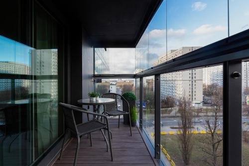 a balcony with a table and chairs on a building at Mennica Residence - City Center by Renters Prestige in Warsaw