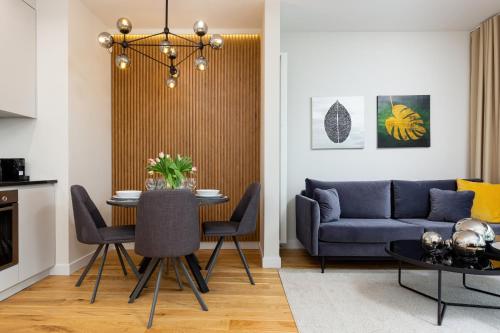a living room with a table and a couch at Mennica Residence - City Center by Renters Prestige in Warsaw