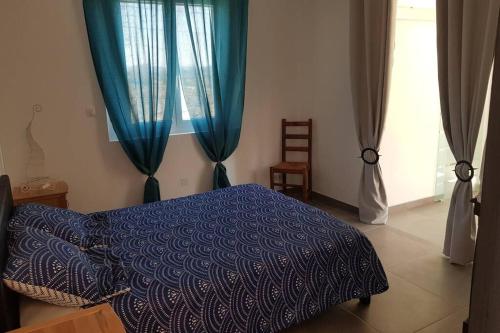 - une chambre avec un lit bleu et des rideaux bleus dans l'établissement LE CALME EN PROVENCE, à Tulette