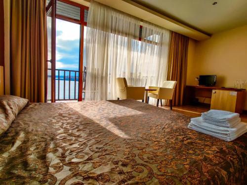 ソゾポルにあるHotel Casa del Mareの大きなベッドとバルコニーが備わるホテルルームです。