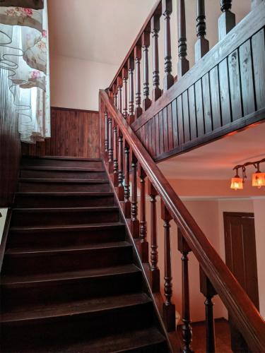 a staircase in an old house with wooden railings at Котедж-парк Славна in Okhtyrka
