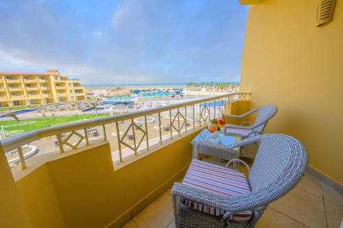 a balcony with two chairs and a view of the beach at Amwaj Beach Club Abu Soma in Hurghada