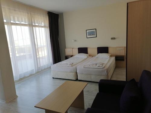 a hotel room with two beds and a table at Aparthotel VRIS in Tsarevo