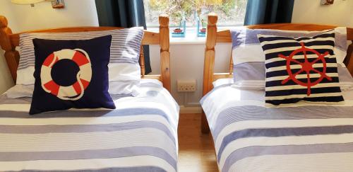 two beds sitting next to each other in a room at Heated Swimming Pool Looe Polperro Cornwall Holiday Home in Looe