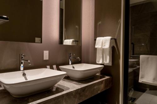 a bathroom with two sinks and a mirror at Park Hotel Kyoto in Kyoto
