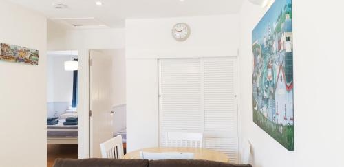 a living room with a couch and a clock on the wall at Heated Swimming Pool Looe Polperro Cornwall Holiday Home in Looe