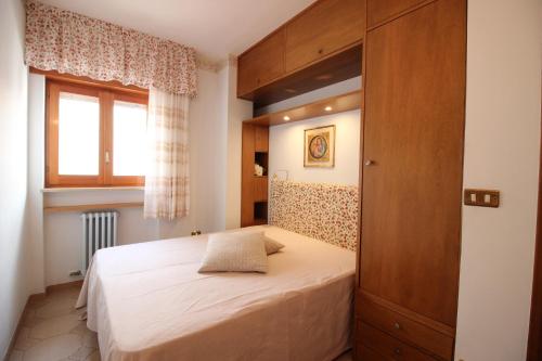 Un dormitorio pequeño con una cama y una ventana. en Villino da Susy, en Otranto