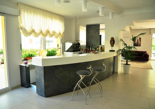 a kitchen with a bar with two stools in it at Hotel Lugano in Riccione