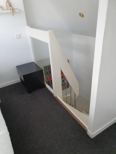 a room with a staircase with a book shelf at PENTY SERVANE in Loctudy