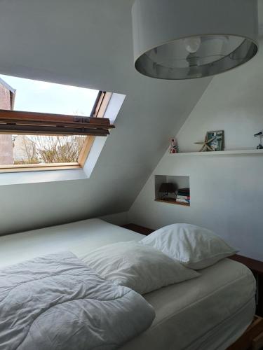 una camera con un letto bianco e una finestra di PENTY SERVANE a Loctudy